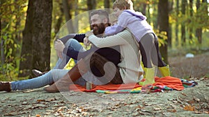 Colorful autumn family portrait. Happy smiling young parents with little son laying in autumn leaves. Young parents and