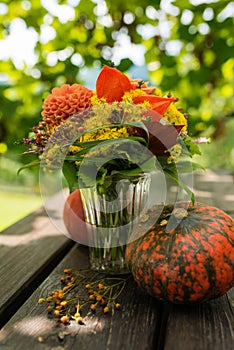 Colorful autumn flowers bouquet with pumpkin