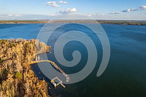 Colorful autumn forest with trees on the shore of a blue lake - top aerial view