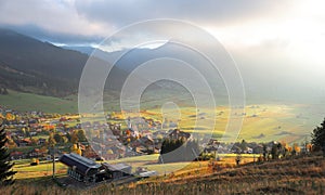 Colorful autumn scenery of Lermoos, a Tyrolean village on green fields bathed in golden sun light