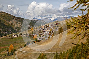 Colorful Autumn scenery with mountain range, fields and Saint Veran village