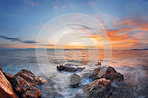 Colorful autumn sunrise on rock beach. Dramatic morning scene of the Ionian Sea, Corfu island location, Greece, Europe