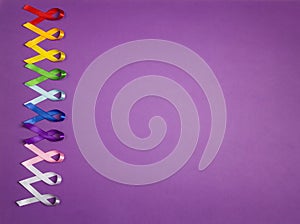 Colorful awareness ribbons on purple background. World cancer day concept, February 4. photo