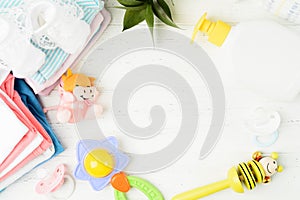 Colorful baby asccessories and clothes flat lay on white wooden background