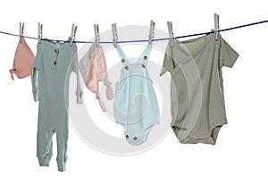 Colorful baby clothes drying on laundry line against background