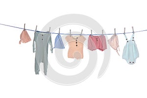 Colorful baby clothes drying on laundry line against white background