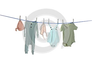 Colorful baby clothes drying on laundry line against white background