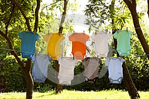 Colorful baby onesies hanging on clothes lines