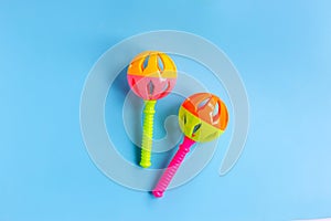 Colorful baby rattle on blue background. Copy space