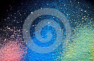 Colorful background of chalk powder. Multicolored dust particles splattered on black background