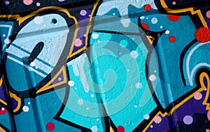 Colorful background of graffiti painting artwork with bright aerosol outlines on wall. Old school street art piece made