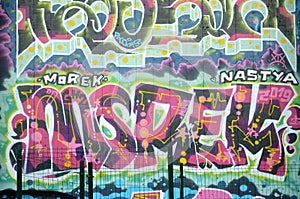 Colorful background of graffiti painting artwork with bright aerosol outlines on wall. Old school street art piece made