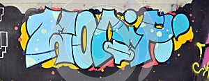 Colorful background of graffiti painting artwork with bright aerosol outlines on wall. Old school street art piece made