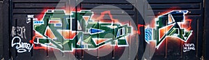 Colorful background of graffiti painting artwork with bright aerosol outlines on wall. Old school street art piece made