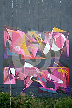 Colorful background of graffiti painting artwork with bright aerosol outlines on wall. Old school street art piece made