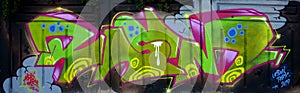 Colorful background of graffiti painting artwork with bright aerosol outlines on wall. Old school street art piece made