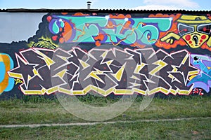 Colorful background of graffiti painting artwork with bright aerosol outlines on wall. Old school street art piece made