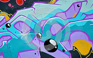 Colorful background of graffiti painting artwork with bright aerosol outlines on wall. Old school street art piece made