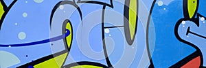 Colorful background of graffiti painting artwork with bright aerosol outlines on wall. Old school street art piece made