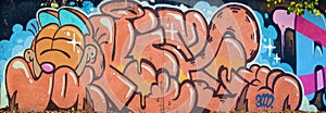 Colorful background of graffiti painting artwork with bright aerosol outlines on wall. Old school street art piece made