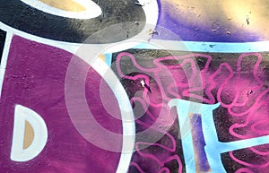 Colorful background of graffiti painting artwork with bright aerosol outlines on wall. Old school street art piece made