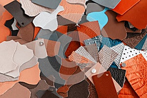 Colorful background of multi-colored pieces of genuine leather of different textures, color swatches for choice
