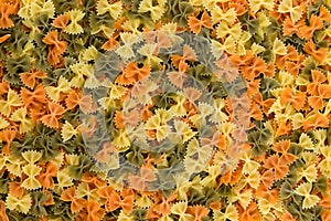 Colorful background of three color farfalle pasta