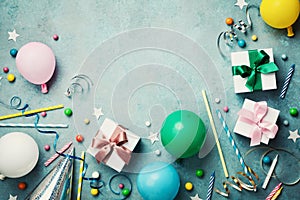 Colorful balloon, present or gift box, confetti, candy and streamer on vintage turquoise table top view. Birthday background.