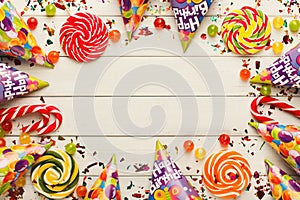 Colorful balloons on white rustic wood, birthday background, top view