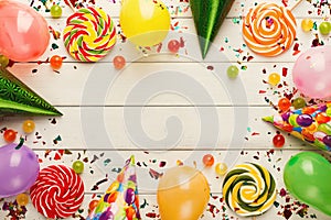 Colorful balloons on white rustic wood, birthday background, top view