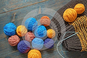 Colorful balls of wool, knitted sweater and knitting needles