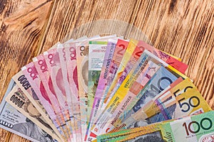 Colorful banknotes in fan on wooden table