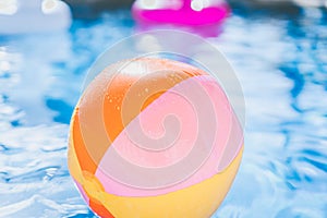 Colorful Beach ball floating in swimming pool. Abstract concept of summer vacations, relaxation and have fun in the
