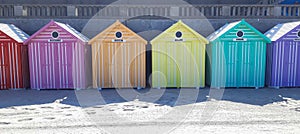Colorful beach huts aligned on the sand