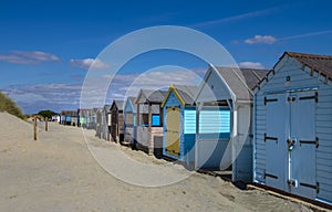 Colorful beach huts on a sandy beach.