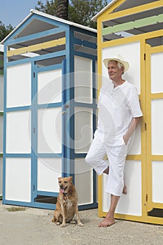 Colorful beach huts and senior man with dog