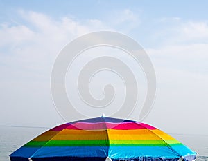 Colorful beach umbrella on sea background