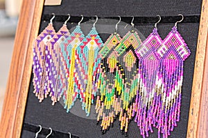 Colorful beaded earrings in boho style - handmade folk style jewelry at souvenir stall, flea market