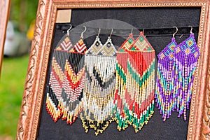 Colorful beaded earrings in boho style - handmade folk style jewelry at souvenir stall, flea market or street market