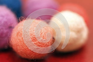 Colorful beads made of felt closeup. Macro photo on a red background