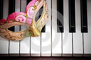 Colorful and beautiful face mask on the black and white piano keyboard keys background