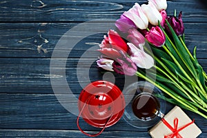 Colorful beautiful pink violet tulips and gift box on gray wooden table. Valentines, spring background. floral mock up.