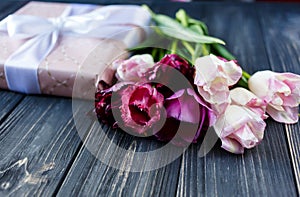 Colorful beautiful pink violet tulips and gift box on gray wooden table. Valentines, spring background. floral mock up.