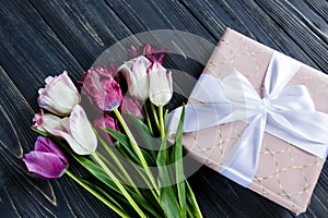 Colorful beautiful pink violet tulips and gift box on gray wooden table. Valentines, spring background. floral mock up