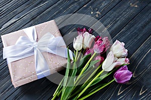 Colorful beautiful pink violet tulips and gift box on gray wooden table. Valentines, spring background. floral mock up