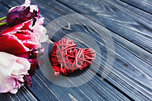 Colorful beautiful pink violet tulips and red heart on gray wooden table. Valentines, spring background. Floral mock up