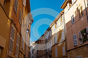 Colorful and beautiful small alley in the old town of the french city of Aix en Provence on a summer day with clear blue sky and