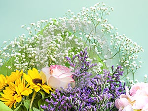 Colorful beautiful spring bouquet closeup. Roses, sunflower, purple flowers