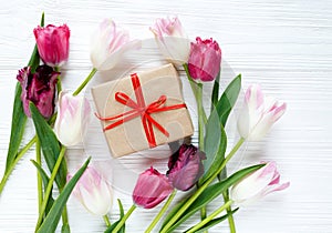 Colorful beautiful tulips and gift box on the white wooden table. Valentines, spring background. floral mock up with copyspace