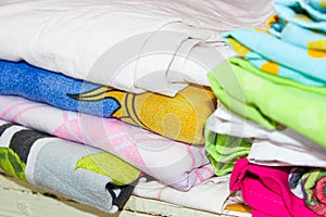 Colorful bed linen in the closet on the shelf